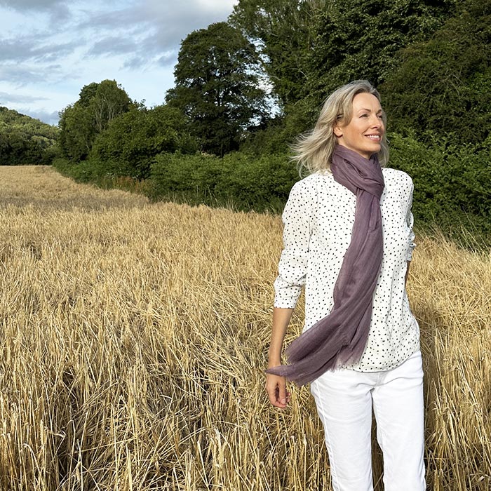 Suzi wearing a cashmere scarf in a field